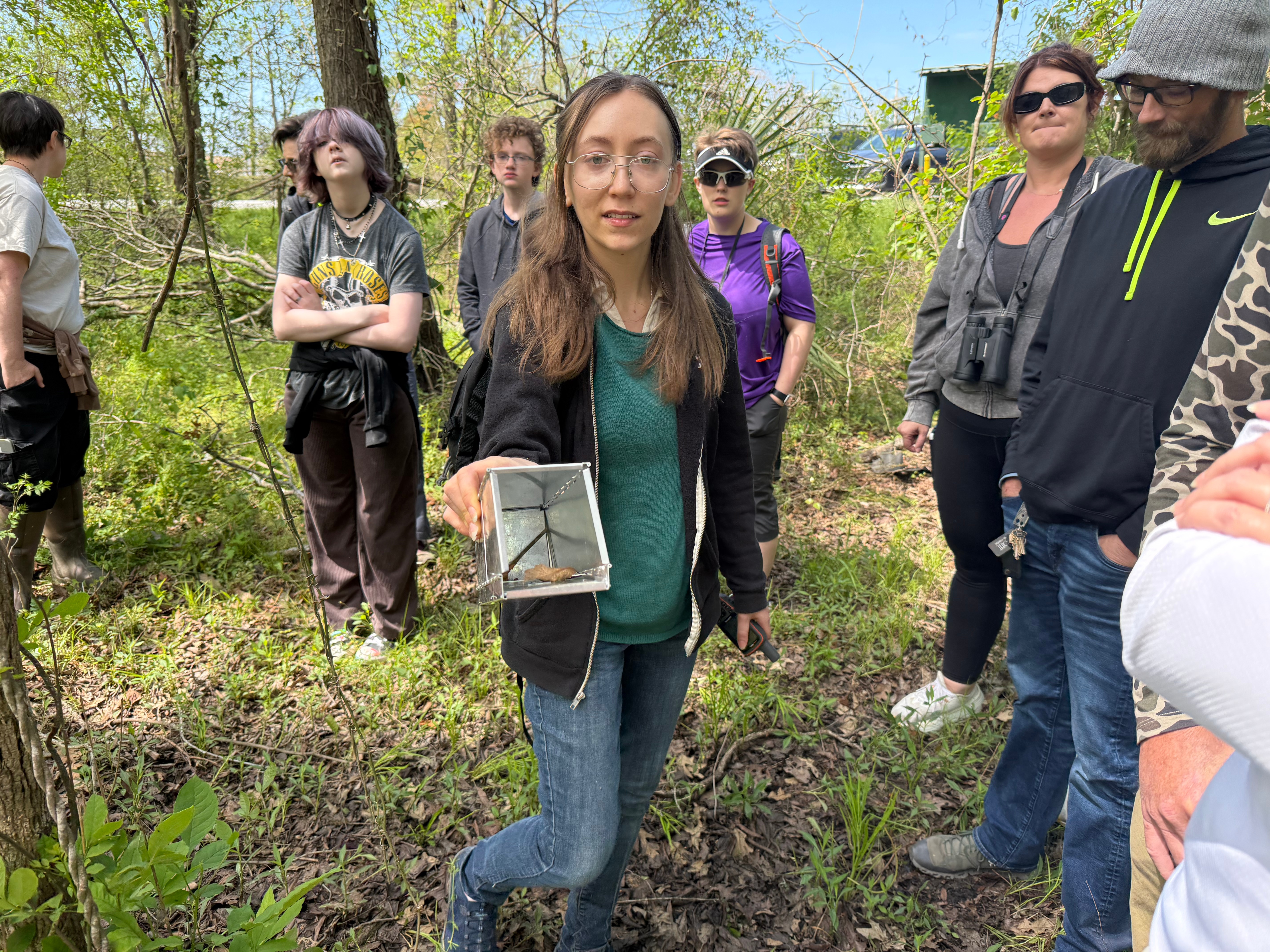 Young female Biology postgrad displaying a humane small mammal trap used in departmental research projects.